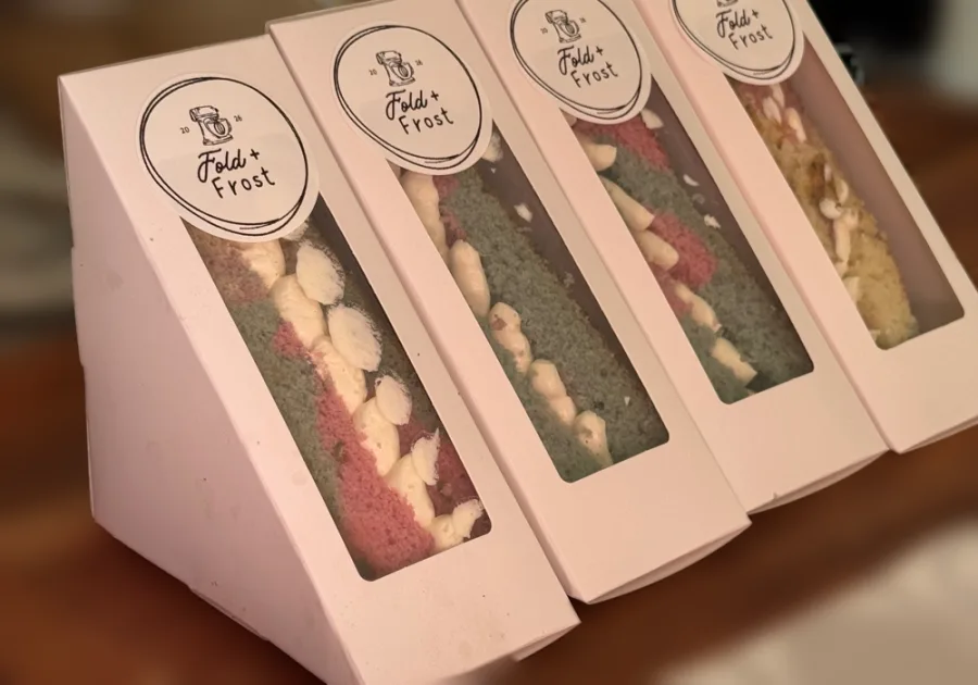 Four cake sandwiches in white windowed boxes, each sealed with a Fold & Frost sticker.